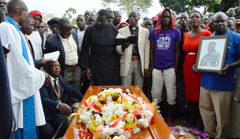 Reverand-Moses-Sejoba-praying-for-Kifulugunyu’s-body-before-it-is-laid-to-rest-WEB